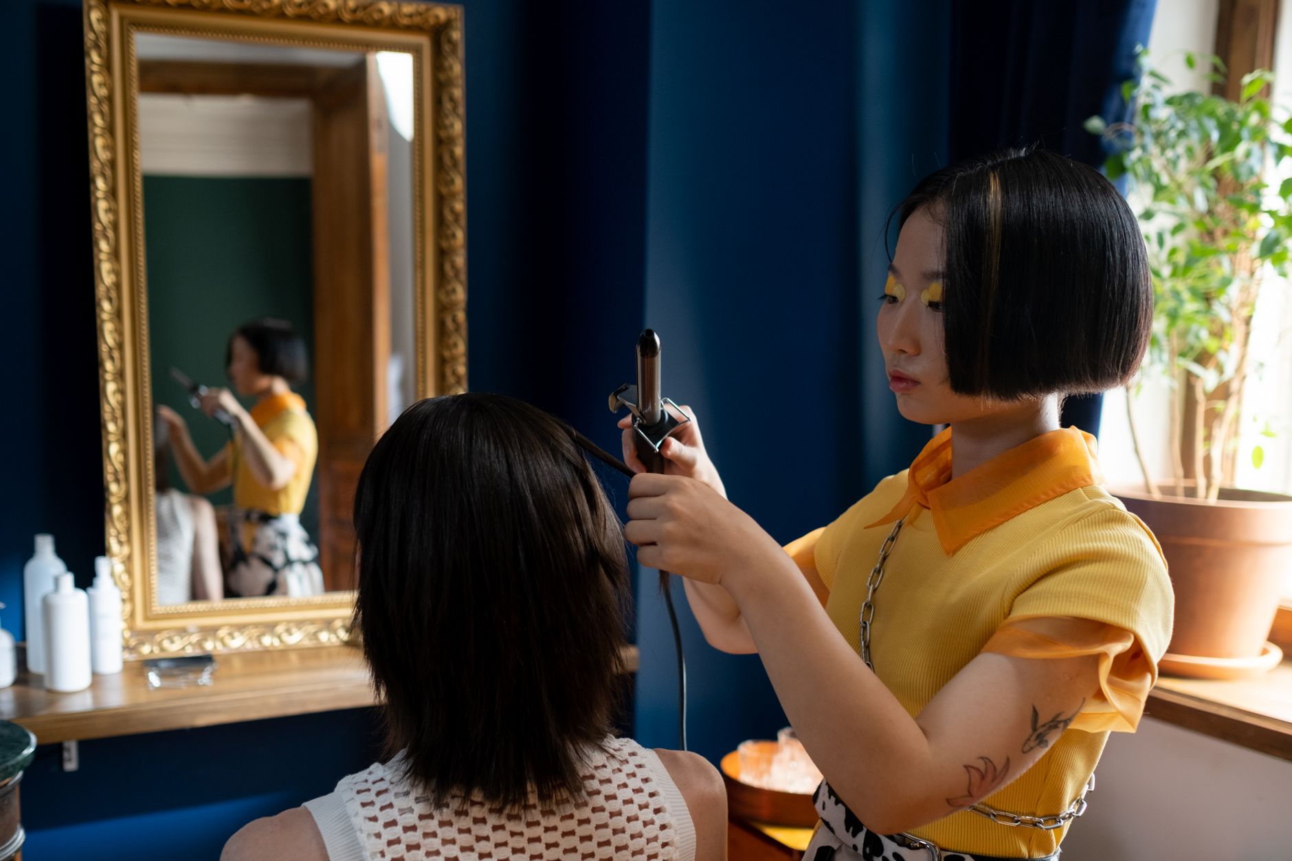 Coiffeuse stylisant une cliente devant le miroir
